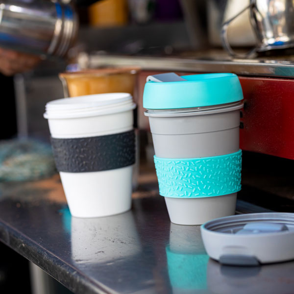 Reusable Travel Mugs Beside A Coffee Machine